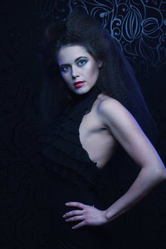 Young brunette woman with high hair and bright make up, gothic style