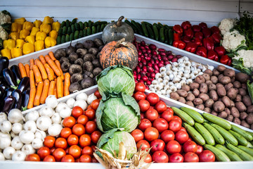 Assortment of fresh vegetables at market counter, vegetable shop, farmer marketplace. Organic, healthy, vegetarian diet food concept.
