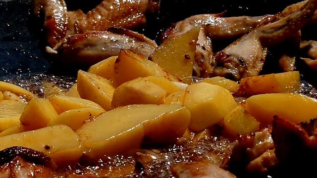 ooking Chicken Wings and Potato Fried In Pan - slow motion