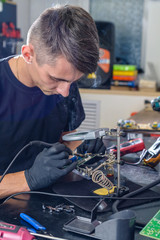 Professional repairman repairing computer in workshop close up