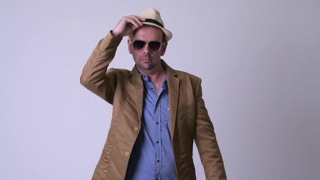 Happy blonde casual businessman greeting with hat