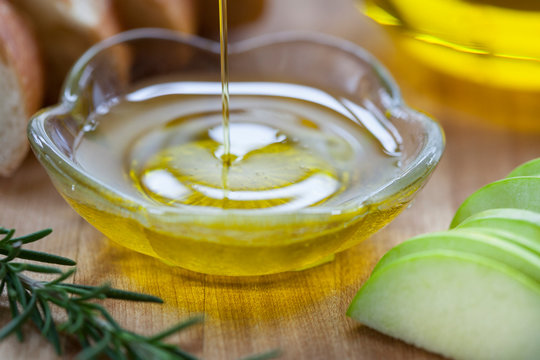 Olive oil being poured into bowl with Italian ingredients