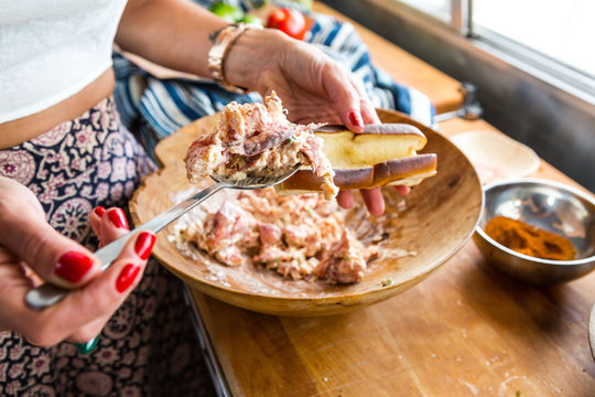 Woman pouring stuffing into bun