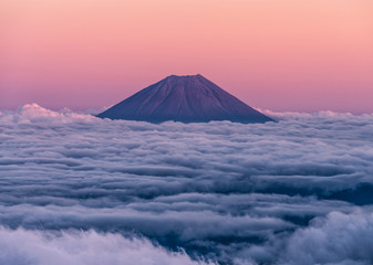 Beautiful volcano, Mt. Fuji, rising above an ocean of clouds at sunset.  Taken from the summit of Mt. Kita.  Mountains of Japan.