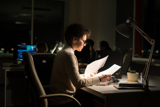 Side view portrait of busy businesswoman working late in dark office, copy space