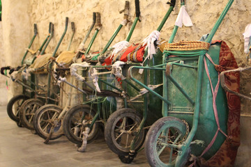 Fototapeta na wymiar Wheelbarrows for carrying goods, leaned up against the wall, in the maketplace Souq Waqif, in Doha, Qatar