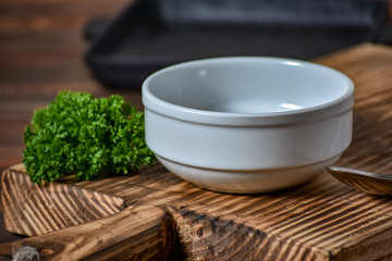 White empty plate for soupe with spoon on the wooden background. Copy text.