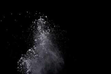 White powder explosion on black background. Dust splatted isolated. Paint Holi.