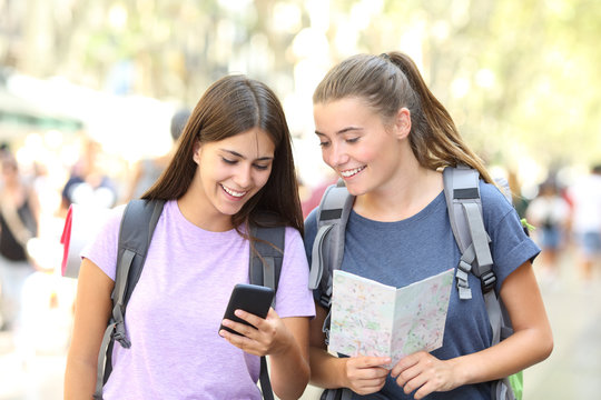 Happy backpackers consulting a guide outdoor