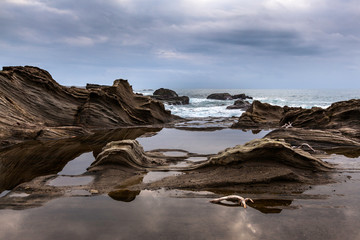 Taiwan East Coast Rocky Coastline Background Image - Overcast Skies, Exotic Rock Formations, Grass and Waves in the Ocean. Ocean Coastline, Asia Landscape Photography, Reflections in water