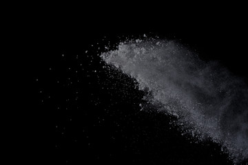White powder explosion on black background. Dust splatted isolated. Paint Holi.