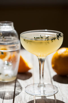 Cocktail in stemmed glass with meyer lemons and thyme