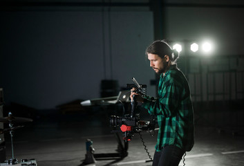 Professional videographer holding camera on 3-axis gimbal. Videographer using steadicam. Pro equipment helps to make high quality video without shaking. © Volodymyr_sh