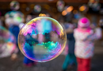 Children trying to catch giant soap bubbles