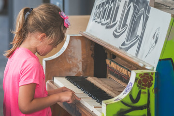 Cute little girl playing on the piano