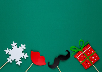 photo booth colorful props for christmas party - red lips, snowflake, gift, moustache on green background. Christmas and New year decorations © Natali
