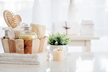 Wooden bucket with SPA accessories on white table.