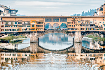 Obraz premium Remando no rio Arno. Vista da ponte vecchio em Florença e um atleta remando no rio. Obras de arte., arte para quadros fineart, impressão de quadros em alta qualidade. 