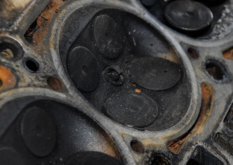 Valve in a deposit on the removed cover of the engine valve box. Engine repair. Imprint of the thread of the bolt that fell into the engine cylinder.