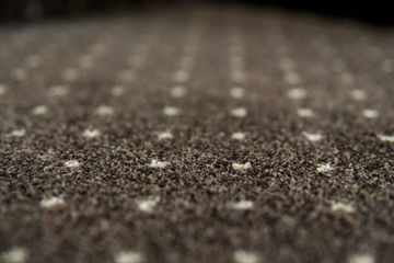 Brown carpet with a white dots texture. Indoor carpeting shoot in daylight.