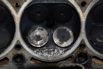 Valve in a deposit on the removed cover of the engine valve box. Engine repair. Imprint of the thread of the bolt that fell into the engine cylinder.
