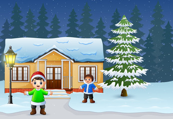 Happy kids playing in front of the snowing house