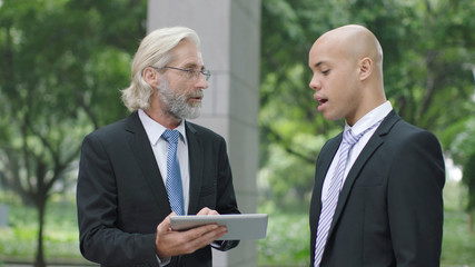 Obraz na płótnie Canvas corporate executives discussing business using digital tablet