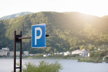 blue parking sign with mountain river view  and sunset