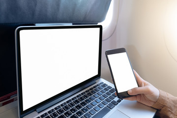 Touching and slide mobile phone screen and laptop on airplane or aircraft,blank mobile phone screen mock up,selective focus
