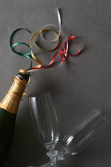 Champagne bottle with colorful ribbons and two glasse