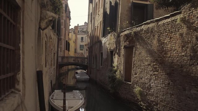 Wide shot of historic water canal street Cale Castagna with brick wall, Venice, Italy