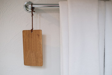 Light bathroom with white towel and wooden label