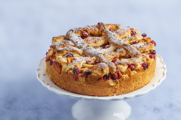 Delicious homemade fruit and berry pie on a white stand.