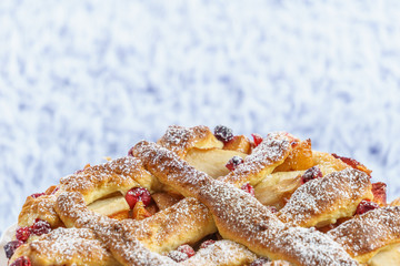 Delicious homemade fruit and berry pie on a white stand.