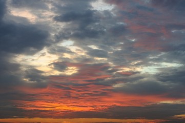 The sunset sky background with dark clouds and sunlight for the dusk moment in the evening.