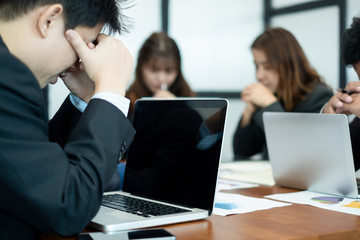 businesspeople sitting at table in office feeling tired and stressed at meeting room, business concept