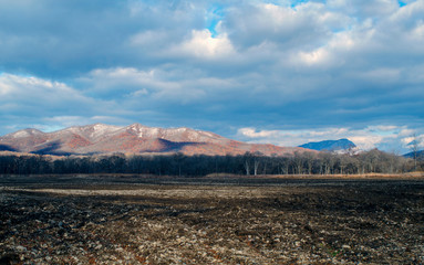 autumn field at the foot of the mountains