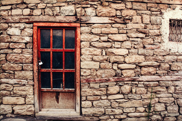 Wooden door locked in a house with a stone facade