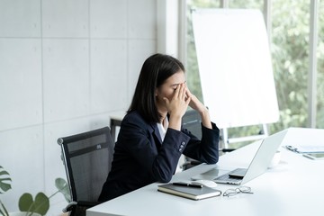 Asian business woman headache stressed because of work mistake problems about profit losses to be...