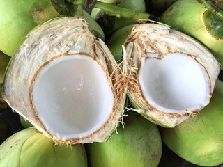 Young fresh coconut cuts in half that can see white color meat which is good to eat for summer.