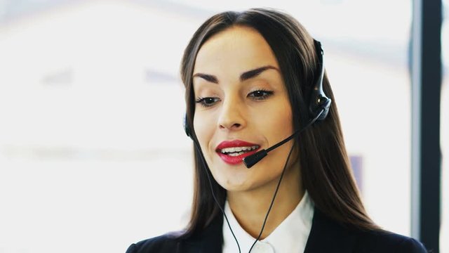 4K. Beautiful woman operator in customer support service center talk with client
