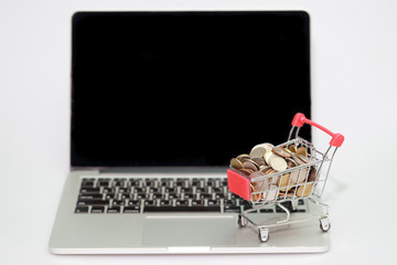 trolley with coins on computer isolated, idea for shopping and online payment using as business...