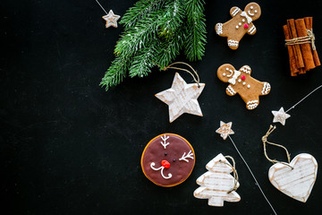 Obraz na płótnie Canvas Festive New Year candies. Traditional gingerbread cookies in different shape for decoration new year tree on black background top view copy space