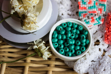 Fototapeta na wymiar Red, white and turquoise beads, beaded bracelet on white woollen cloth. Handmade