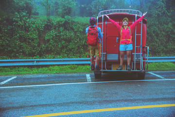 Lover asian man and asian women travel nature. Nature Study in the rain forest Amid the mist  rainyat. Travel by Minibus at Chiangmai in Thailand.
