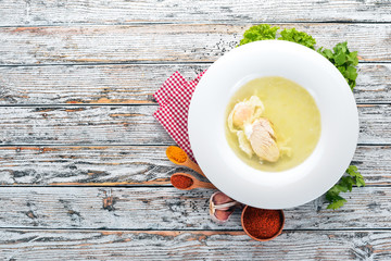 Chicken soup with egg. On the old wooden background. Free space for text. Top view.