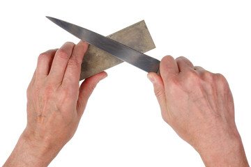 Old elderly cook tries to sharpen steel  long  kitchen knife. Isolated