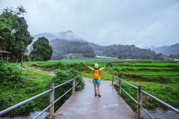 Asian women travel nature. Walking a photo the rice field and stop take a break relax on the bridge...