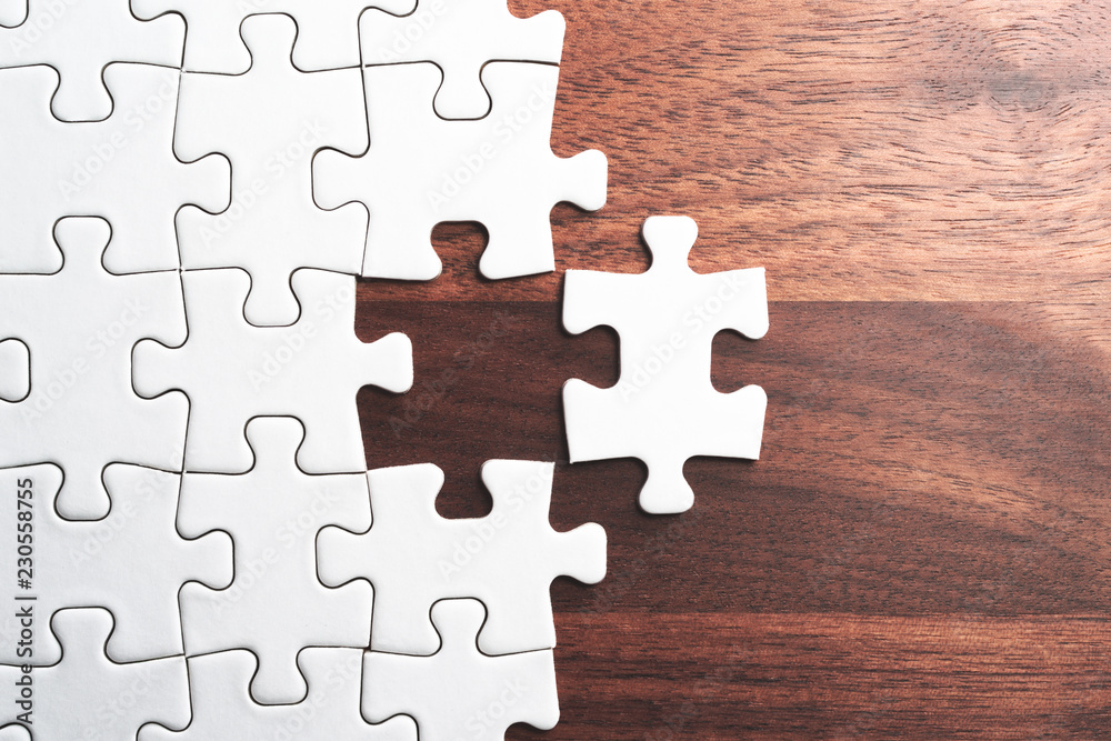 Poster assembling jigsaw puzzle pieces. abstract background.unfinished white jigsaw puzzle pieces on wood t