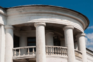 Old building with columns and balcony against the blue sky